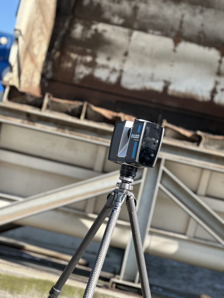 Detailaufnahme eines 3D Scanners mit Bauteil im Hintergrund